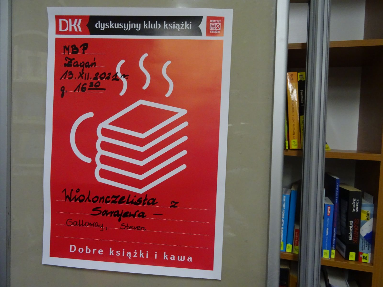 Zdjęcie. Tablica z różowym plakatem Godzinami o Książkach i informacją o spotkaniu Dyskusyjnego Klubu Książki 